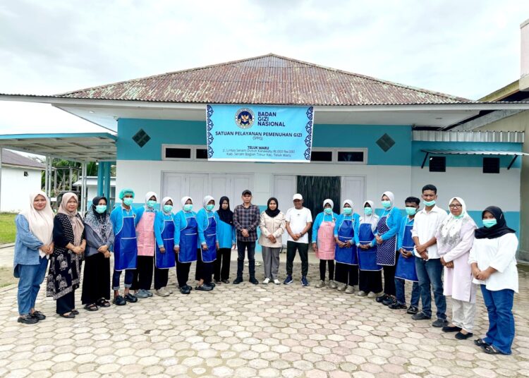Plt Kepala Dinas Ketapang SBT dan staf melakukan foto bersama dengan tim pengelola program MBG di Kecamatan Teluk Waru. (Dok : Ist)