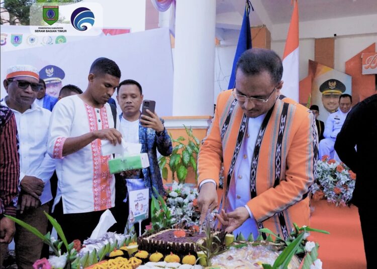 Bupati SBT Fachri Husni Alkatiri melakukan pemotongan kue yang dibuat menggunakan bahan dasar sagu pada upacara HUT SBT ke-22 tahun. (Dok : Kominfo SBT)