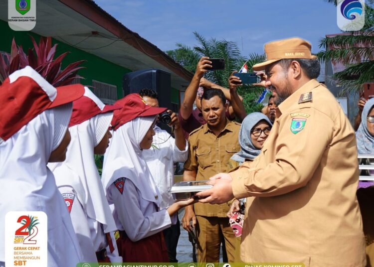 Wakil Bupati SBT M. Miftah Thoha R. Wattimena menyerahkan paket MBG kepada pelajar usai melaunching tiga SPPB di Kecamatan Bula. (Dok : Dinas Kominfo SBT)