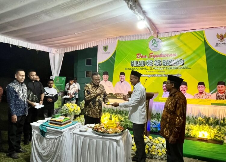 Ketua Baznas SBT Zainudin Kelsaba memotong tumpeng dan memberikan kepada Bupati SBT Fachri Husni Alkatiri (Dok : Pribadi)